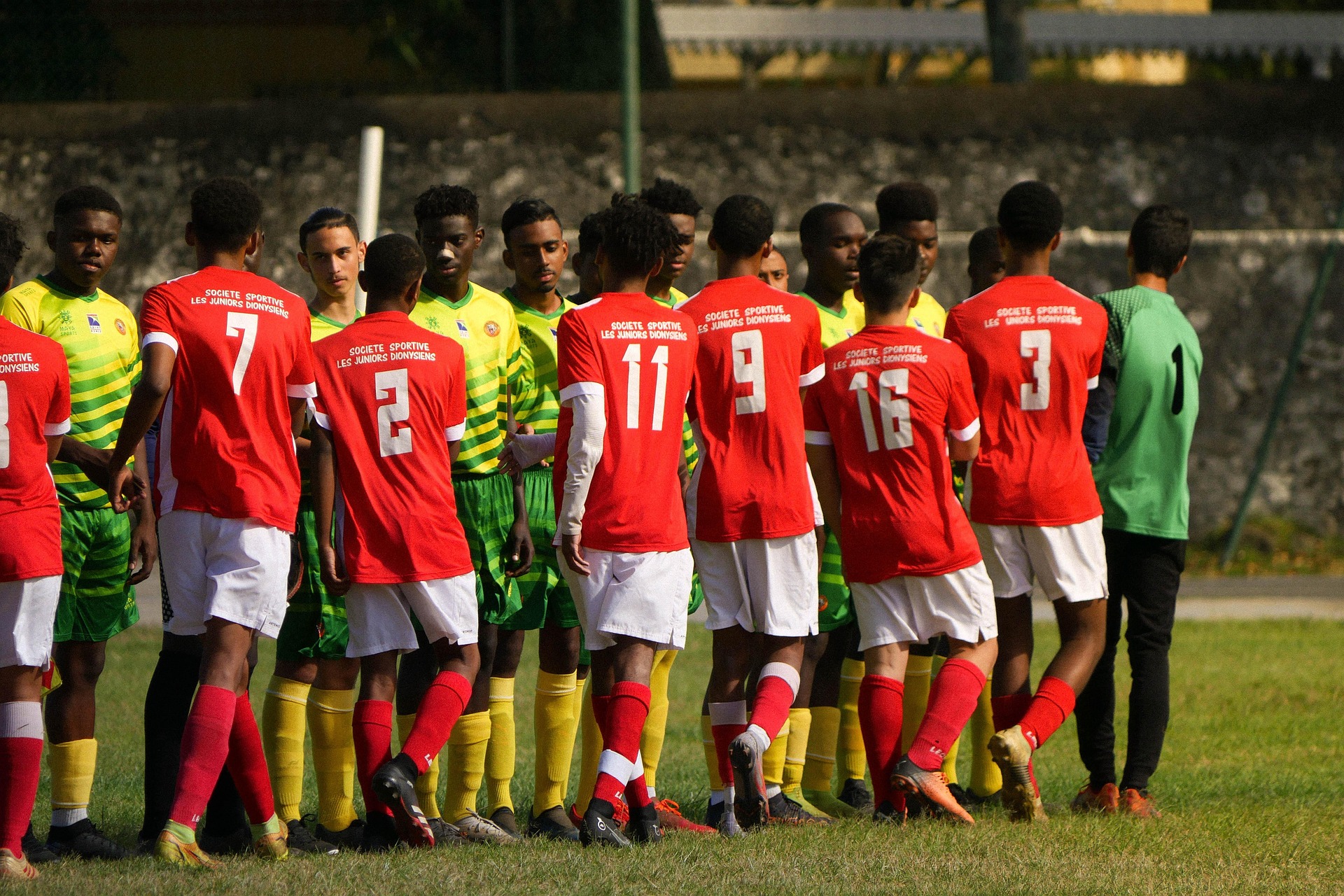 Youth football teams greeting each other before a match
